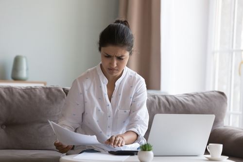 Woman looking angry at paystub